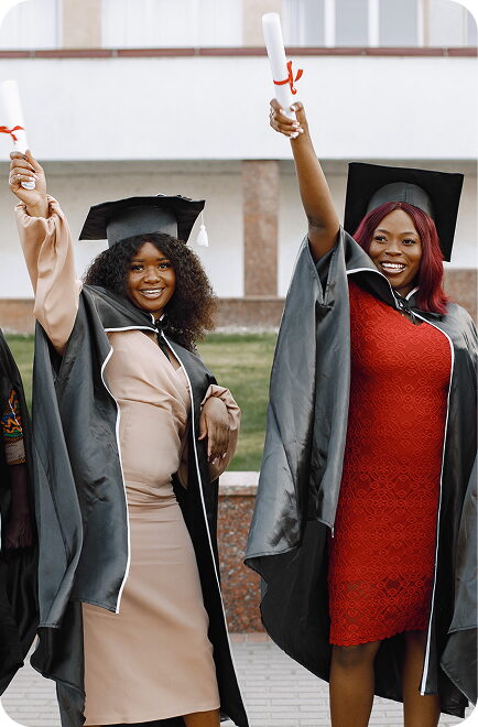 Two FGC Kano graduates raising their diplomas in celebration