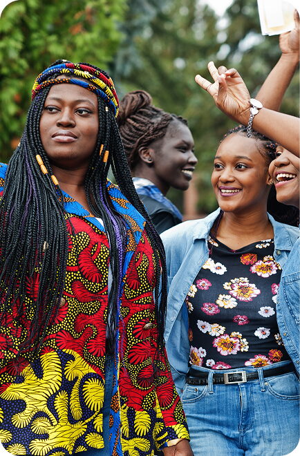 An FGC Kano alumna in patterned dress taking a selfie with friends