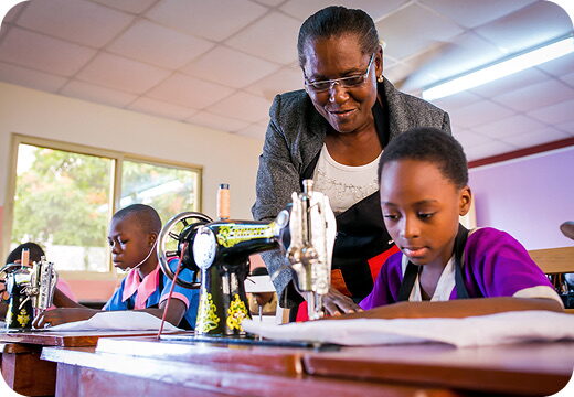 Students learning to use sewing machines with an instructor