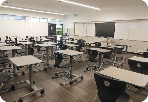 A modern classroom with movable desks and a whiteboard